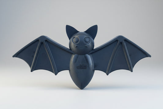 Black bat-shaped toy on a white background