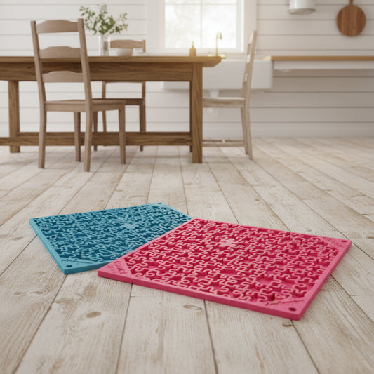 Two textured silicone mats, one pink and one blue, on a white background.